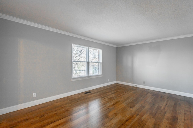 empty room featuring a textured ceiling, dark hardwood / wood-style floors, and ornamental molding