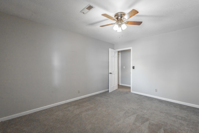 carpeted empty room featuring ceiling fan and a textured ceiling