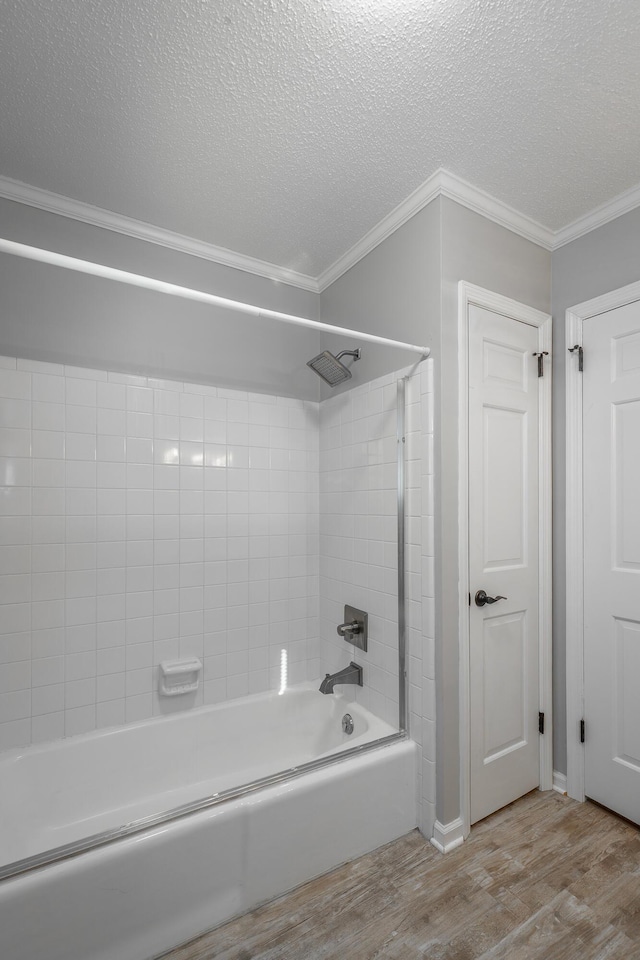 bathroom featuring shower / bath combination, wood-type flooring, a textured ceiling, and ornamental molding