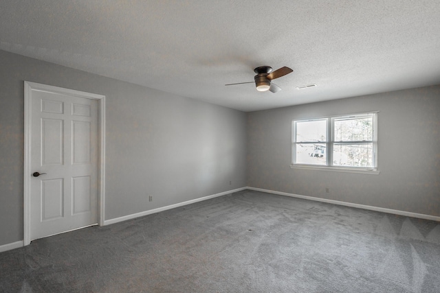 unfurnished room featuring dark colored carpet, ceiling fan, and a textured ceiling