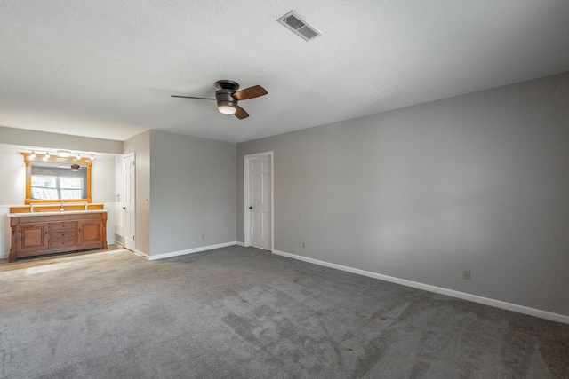 unfurnished bedroom with carpet flooring, ceiling fan, a textured ceiling, and connected bathroom