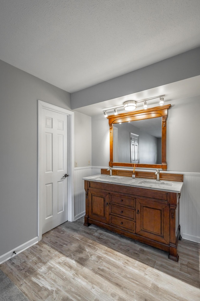 bathroom with vanity, wood-type flooring, and a textured ceiling