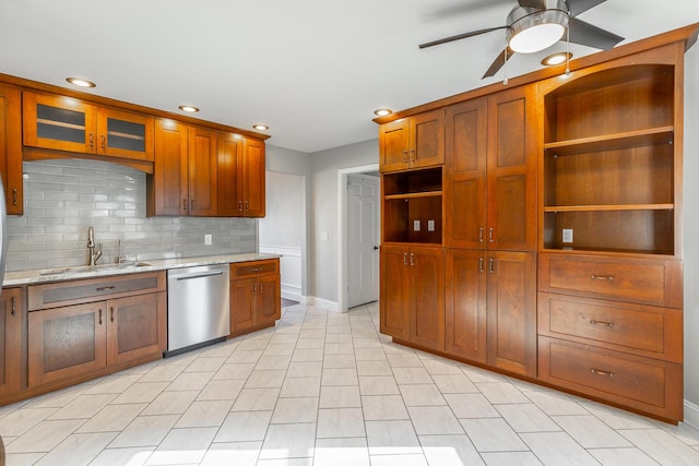 kitchen featuring light stone countertops, dishwasher, ceiling fan, sink, and tasteful backsplash