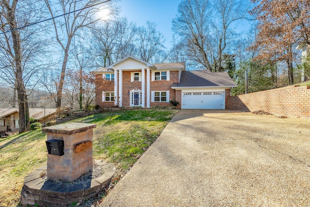 greek revival inspired property with a front lawn and a garage