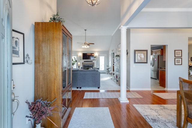 entryway featuring ornate columns, ceiling fan, light hardwood / wood-style floors, and crown molding