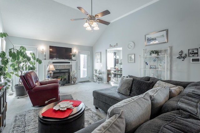 living room featuring a tiled fireplace, ceiling fan, ornamental molding, high vaulted ceiling, and light colored carpet