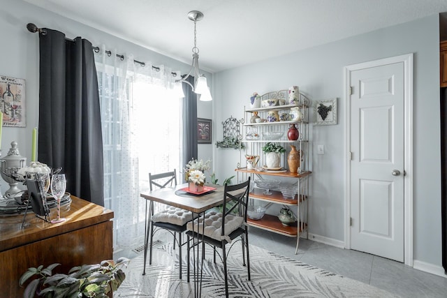 tiled dining area with a chandelier