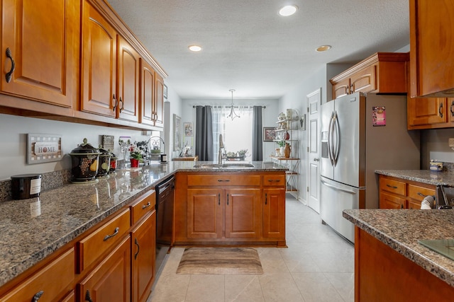 kitchen with kitchen peninsula, a textured ceiling, a chandelier, decorative light fixtures, and sink