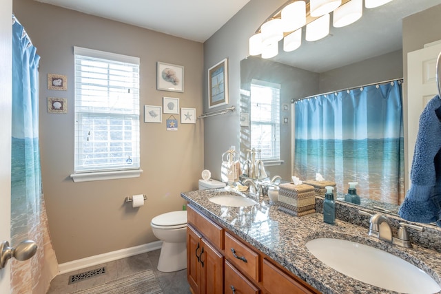 bathroom featuring toilet, vanity, and a healthy amount of sunlight