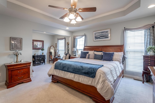 carpeted bedroom featuring a raised ceiling, ceiling fan, and ornamental molding