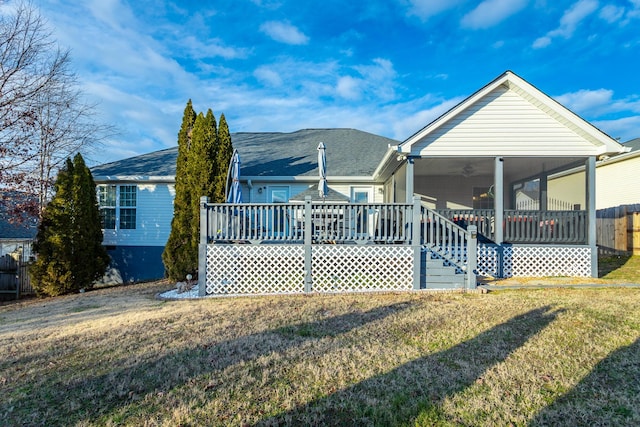 back of property featuring ceiling fan, a wooden deck, a sunroom, and a lawn