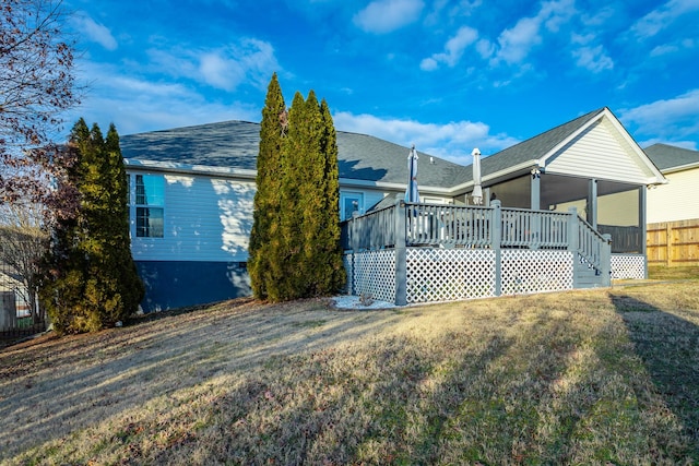 view of home's exterior with a deck and a yard