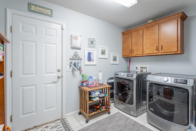 laundry area featuring cabinets, separate washer and dryer, and light tile patterned floors