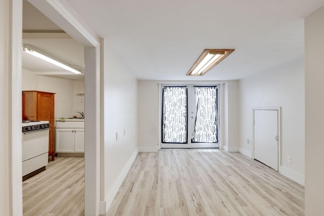 spare room featuring sink, light hardwood / wood-style flooring, and french doors