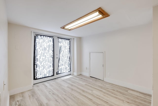 unfurnished room featuring light wood-type flooring and french doors