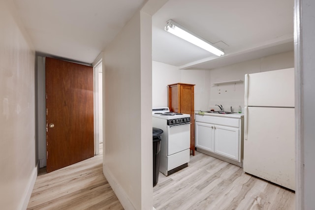 kitchen featuring light hardwood / wood-style floors, sink, white appliances, and white cabinets