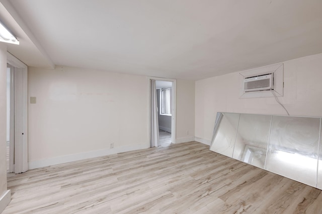 empty room featuring light hardwood / wood-style floors and an AC wall unit