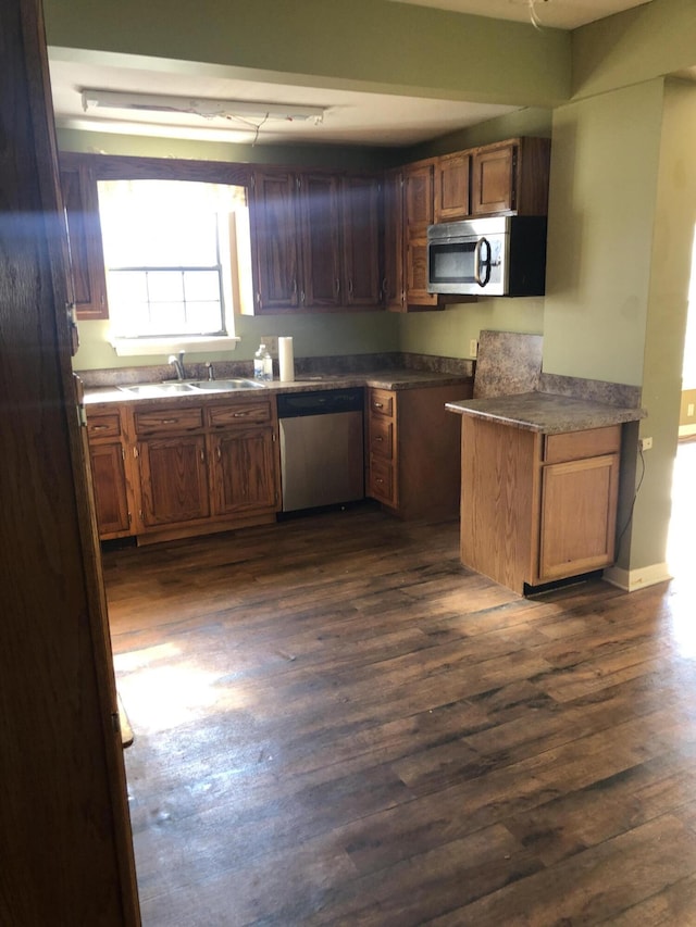 kitchen featuring sink, appliances with stainless steel finishes, and dark wood-type flooring