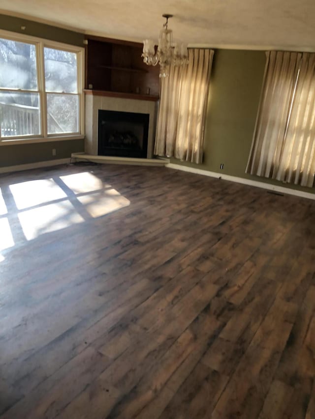 unfurnished living room featuring dark hardwood / wood-style floors and a notable chandelier