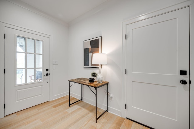 entryway with crown molding, plenty of natural light, and light wood-type flooring