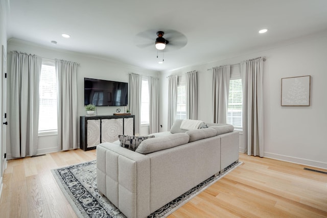 living room with ceiling fan, a healthy amount of sunlight, and light wood-type flooring