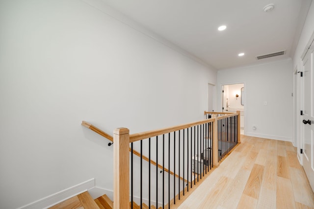 corridor featuring light hardwood / wood-style flooring and crown molding