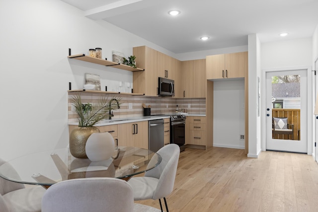 kitchen with sink, light hardwood / wood-style flooring, decorative backsplash, light brown cabinetry, and stainless steel appliances