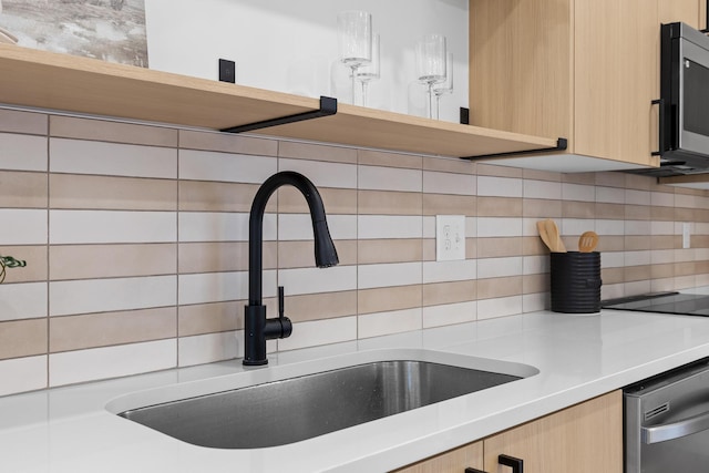 kitchen with appliances with stainless steel finishes, tasteful backsplash, light brown cabinetry, and sink