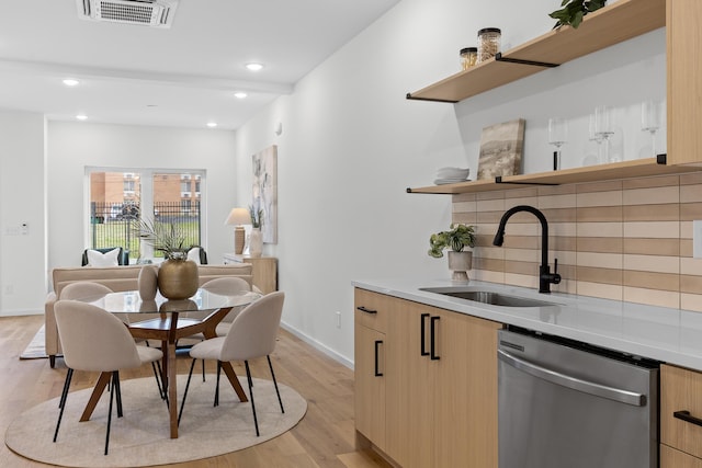 dining area with beam ceiling, light hardwood / wood-style floors, and sink