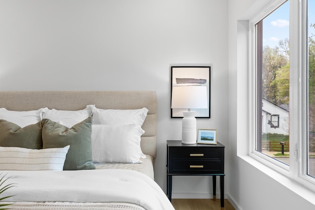 bedroom with hardwood / wood-style floors and multiple windows