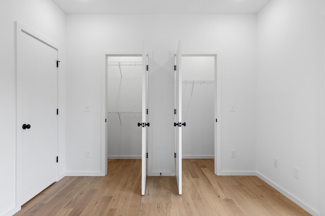 interior space featuring a walk in closet and light hardwood / wood-style flooring