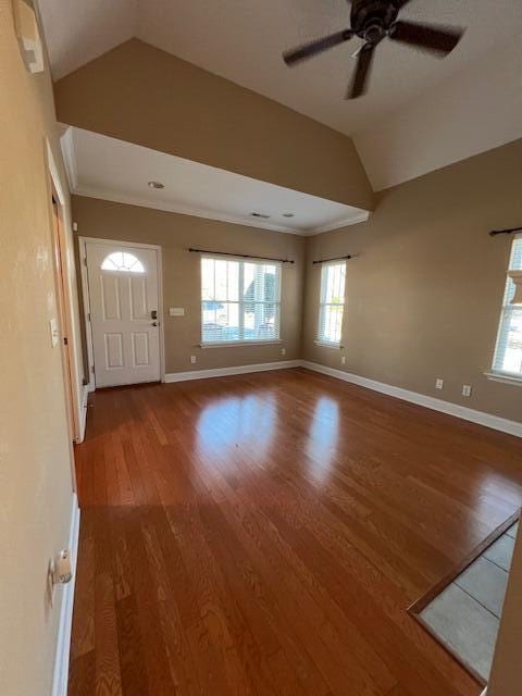 interior space with hardwood / wood-style flooring, vaulted ceiling, ceiling fan, and ornamental molding