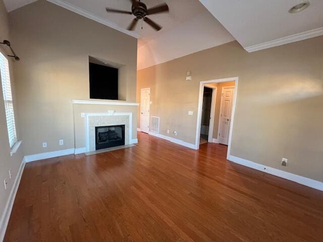 unfurnished living room with ceiling fan, crown molding, vaulted ceiling, a fireplace, and hardwood / wood-style flooring