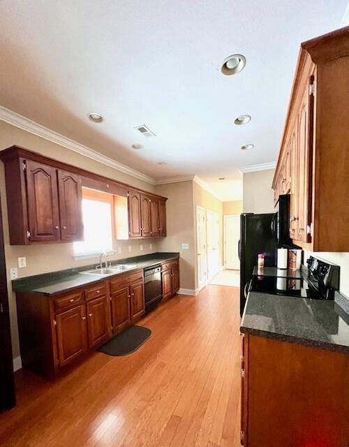 kitchen with black appliances, light wood-type flooring, sink, and ornamental molding