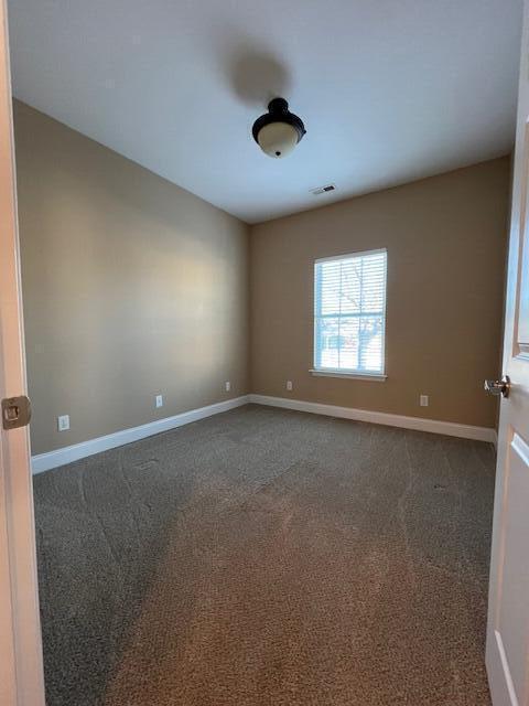 empty room featuring dark carpet