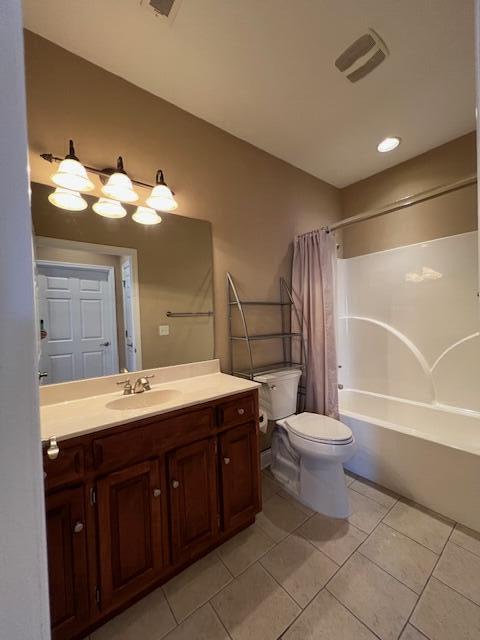 full bathroom featuring tile patterned flooring, vanity, toilet, and shower / bath combo with shower curtain