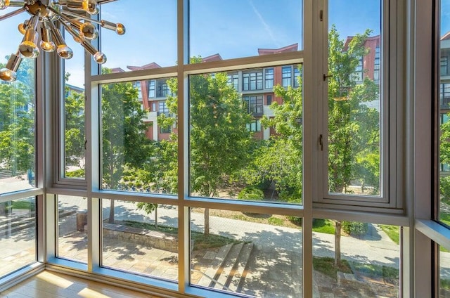 unfurnished sunroom featuring a notable chandelier and a healthy amount of sunlight