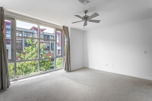 carpeted spare room with ceiling fan and ornamental molding