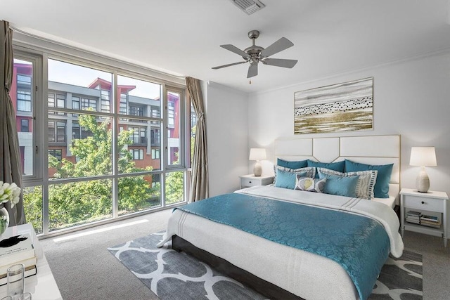 carpeted bedroom with ceiling fan and ornamental molding