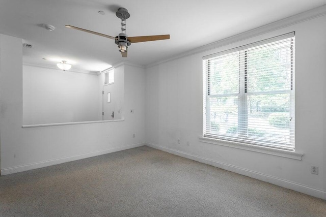 carpeted empty room featuring ceiling fan and crown molding