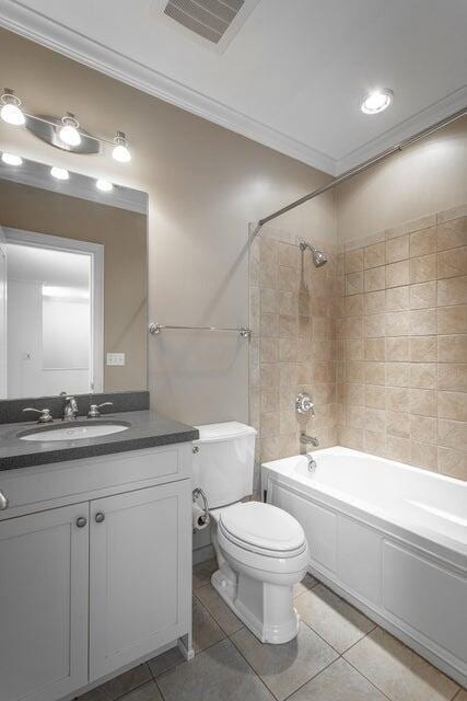 full bathroom featuring vanity, tiled shower / bath, tile patterned flooring, toilet, and ornamental molding