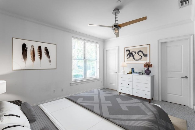 carpeted bedroom with ceiling fan and ornamental molding