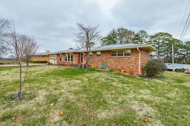 rear view of property with a yard and a garage