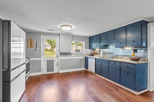 kitchen featuring blue cabinetry, sink, and white dishwasher