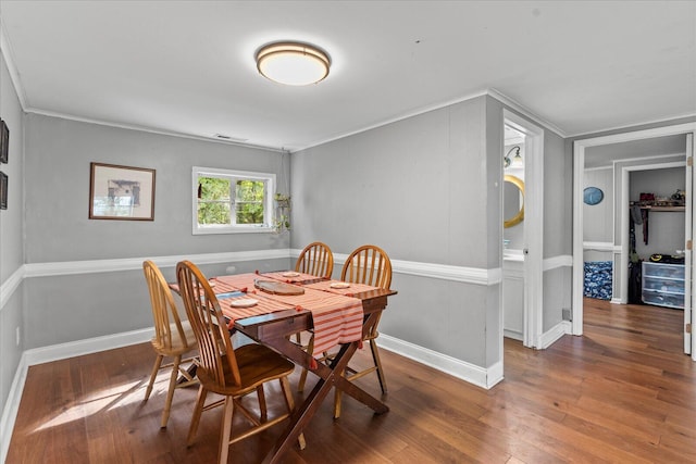 dining room featuring dark wood-type flooring and ornamental molding