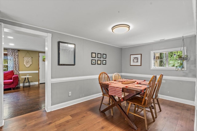 dining space featuring dark hardwood / wood-style floors and ornamental molding