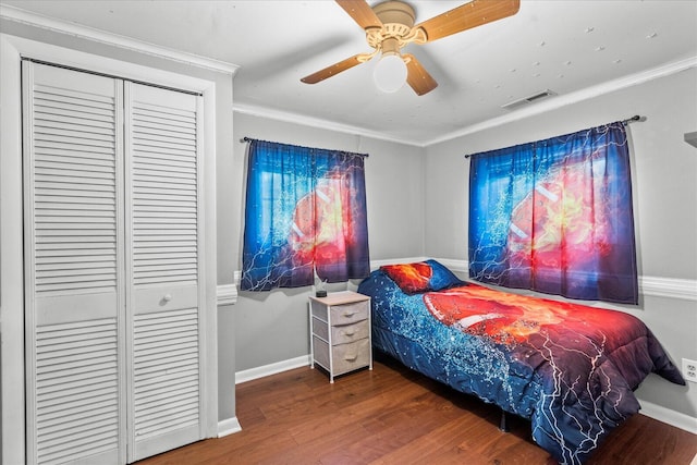 bedroom with a closet, hardwood / wood-style flooring, ceiling fan, and ornamental molding