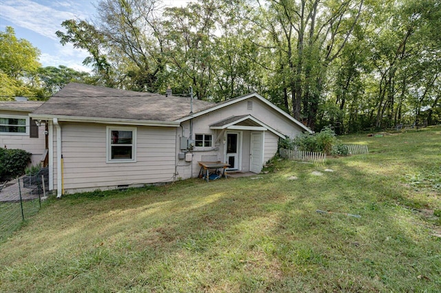 rear view of property with a yard