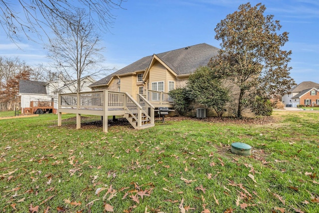 rear view of property with a yard and a wooden deck