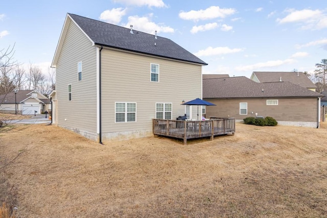 rear view of property featuring a yard and a deck